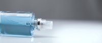 Blue liquid cosmetic serum in glass dropper bottle on white surface for skincare and beauty treatment applications.