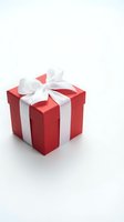 Red gift box with white satin ribbon bow isolated on white background, perfect for holiday, Christmas, and celebration concepts.