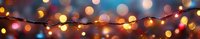 Glowing string lights with warm bokeh effect against dark background creating festive holiday atmosphere and magical ambiance.