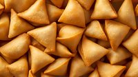 Golden crispy samosas arranged in repeating pattern showcasing traditional Indian appetizer snacks for restaurant menus and food photography backgrounds.