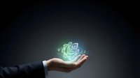 Business professional hand presenting glowing green recycling symbol with digital effects against dark background for environmental sustainability concepts.