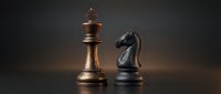 Golden king and black knight chess pieces facing each other on dark surface representing strategic competition and business rivalry concepts.