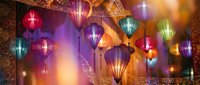 Colorful traditional Asian lanterns hanging in warm ambient lighting creating festive atmosphere for celebrations and cultural events.