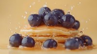 Fresh blueberries with golden honey dripping on warm beige background. Organic superfood berries with natural sweetness for healthy eating and cooking.