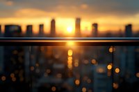 Urban skyline silhouette at golden hour sunset with glass balcony railing reflecting warm light and city bokeh for modern architecture backgrounds.