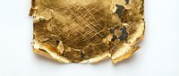 Crumpled gold foil sheet with torn edges and metallic texture on white background, suitable for luxury branding, packaging design, and premium product presentations.