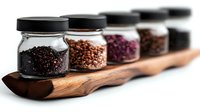 Assorted spices and seeds in glass jars with black lids arranged on wooden serving board, showcasing culinary ingredients for cooking.