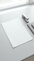 Clean white desk workspace with blank paper sheet, stapler and pens near window for office productivity and business planning mockup templates.