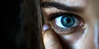 Close-up macro shot of intense blue human eye with digital reflection and technology concept. Dark atmospheric lighting creates dramatic effect for cybersecurity themes.
