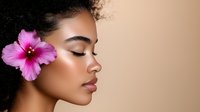 Young African American woman with natural curly hair and pink hibiscus flower, side profile showing glowing skin, closed eyes, and glossy lips against beige background.
