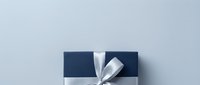 Gift box with navy blue and white striped wrapping paper and silver ribbon bow on light gray background, suitable for holiday, birthday, and celebration design projects.
