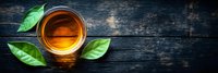 Cup of aromatic tea with fresh green leaves on dark rustic wooden background, top view with copy space. Warm drink concept for cafe menu.