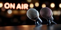Two professional microphones against blurred on air sign and bokeh lights background, capturing live performance atmosphere in broadcasting studio.