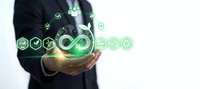 Businessman holding glowing green sustainability icons representing circular economy and environmental responsibility in corporate strategy.