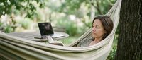 Woman relaxing in hammock with laptop in garden, remote work and outdoor leisure lifestyle concept for freelance professionals.