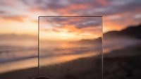 Transparent glass frame overlay on blurred sunset beach scene with golden sky and ocean waves. Modern minimalist border for design projects and presentations.