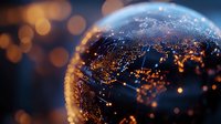 Glowing city lights reflected in glass sphere with bokeh background creates magical night urban view. Artistic macro photography captures metropolitan energy.