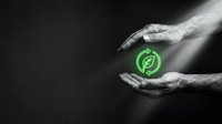 Hands holding glowing green recycling symbol on dark background, representing sustainability, environmental responsibility, and eco-friendly business practices.