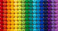 Colorful rainbow gradient pattern of round beads arranged in organized rows from red to purple creating vibrant spectrum display for craft projects.
