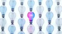 Creative innovation concept with glowing pink lightbulb standing out among transparent bulbs on white background for business presentations.