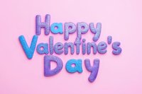 Glittery purple and blue Happy Valentine's Day text on pink background, festive holiday typography with sparkly texture effect for greeting cards and social media.