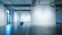 Modern minimalist art gallery interior with white walls, polished concrete floors, exposed ceiling beams and large windows for contemporary exhibitions.