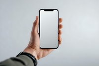 Hand holding modern smartphone with blank white screen against neutral background for mockup presentations and app development projects.