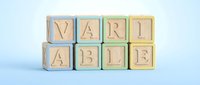Wooden alphabet blocks spelling VARIABLE arranged in two rows on light blue background for educational and business concept presentations.