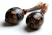 Traditional Mexican wooden maracas with colorful hand-painted floral designs and natural fiber tassels for music and cultural celebrations.
