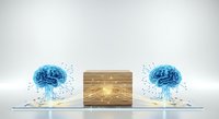 Two glowing blue brain illustrations with particle effects flanking a wooden box with illuminated lightbulb symbol on white surface, representing innovation and knowledge exchange.