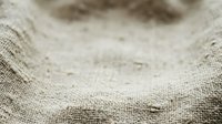 Natural burlap fabric texture with soft focus creating rustic background for organic product displays and eco-friendly design projects.
