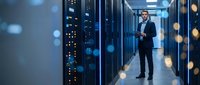 Male IT professional in business attire inspecting server racks in modern data center facility. Suitable for technology, cloud computing, cybersecurity, and enterprise infrastructure projects.