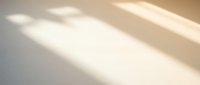 Soft warm sunlight casting gentle shadows on clean white surface creating minimalist abstract background for modern design projects and presentations.