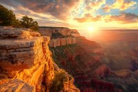 Majestic sunset over Grand Canyon with golden light illuminating rocky cliffs and deep valleys, dramatic sky with colorful clouds.