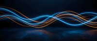 Abstract flowing light waves in blue and orange colors against dark background, suitable for technology, energy, and digital design projects.