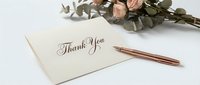 Elegant thank you card with rose gold pen and dried eucalyptus flowers on white background for wedding stationery and gratitude messages.
