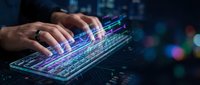 Male programmer typing on futuristic holographic keyboard with glowing code streams and digital interface elements in dark tech environment.