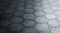 Close-up of metallic hexagonal tiles with textured surface and depth of field effect, suitable for backgrounds, technology, and industrial design projects.