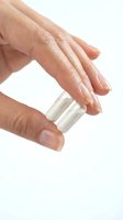 Woman hands applying white cream from jar on white background for skincare and beauty routine.