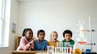 Young diverse students conducting science experiment with test tubes and colorful liquids in classroom laboratory setting, exploring chemistry and STEM education.