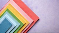Colorful layered paper sheets arranged in geometric diagonal composition with soft shadows on purple background. Modern minimalist design for creative projects.