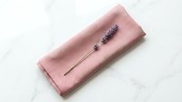 Dusty rose linen clutch wallet with dried lavender sprig decoration, isolated on white marble background, ready for product photography and e-commerce design use.