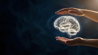Hands protecting glowing brain hologram on dark background symbolizing mental health care, neurology, psychology, and cognitive protection concepts.