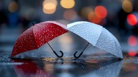 Red and white umbrellas with water droplets touching on wet surface against blurred city lights background creating romantic rainy day atmosphere.