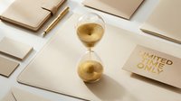 Gold hourglass with limited time only card on beige desk with stationery, symbolizing urgency, deadline, and exclusive offer concept.