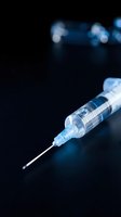 Medical syringe with needle on dark background with blue bokeh lights for healthcare and vaccination concepts.