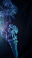 Swirling blue and teal smoke rising against a dark background, forming elegant abstract curls and spirals for creative design projects.