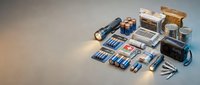 Collection of various lithium ion batteries and power sources arranged on neutral background for electronic device energy storage applications.