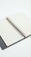 Open spiral-bound notebook with blank grid pages and metal binding, isolated on white background, ready for design mockups and educational content.
