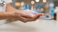Young adult male professional holding holographic data analytics charts and growth graphs in palm of hand, representing business intelligence and financial success.